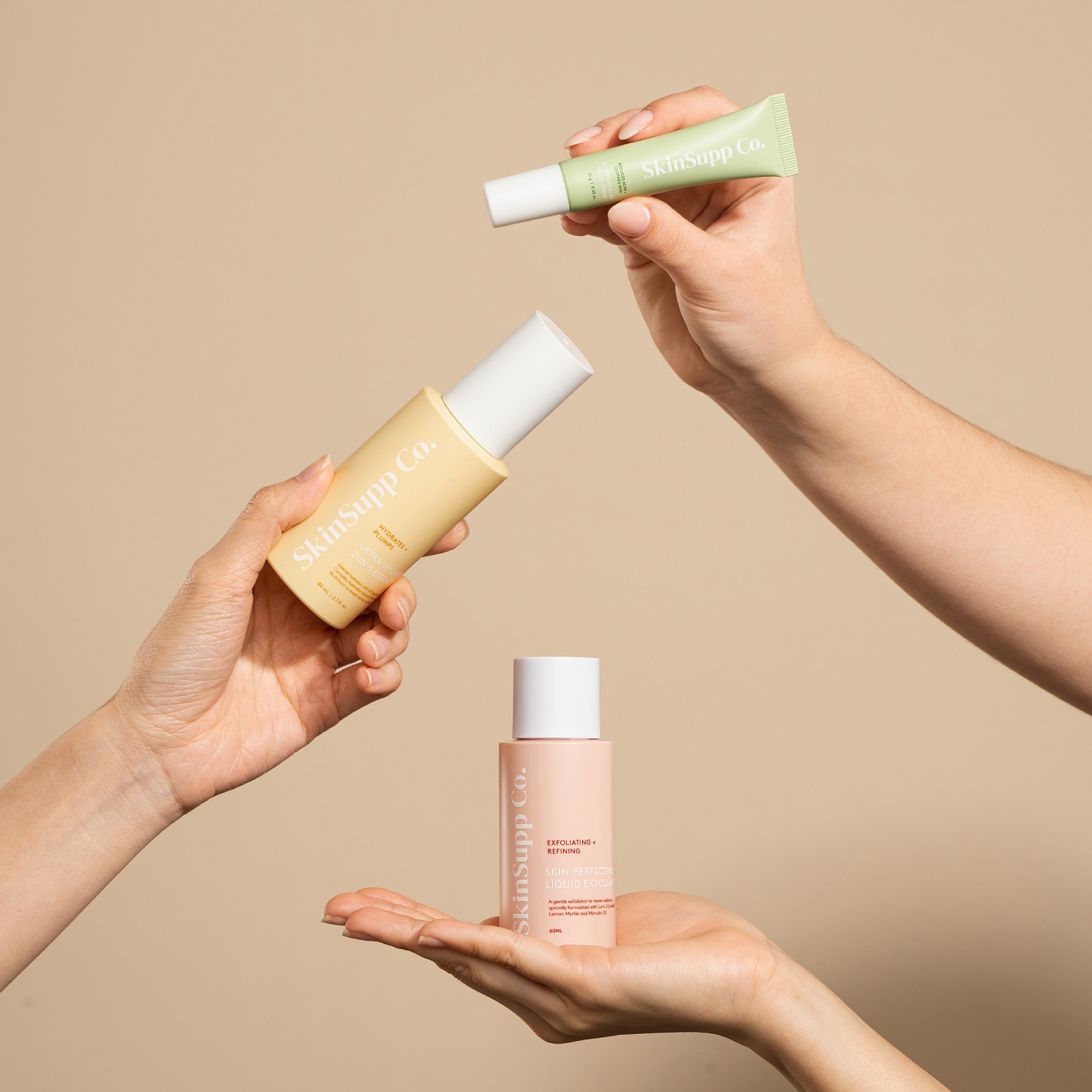 Hands holding up a bottle of skin care products, showcasing the essence of self-care and beauty.